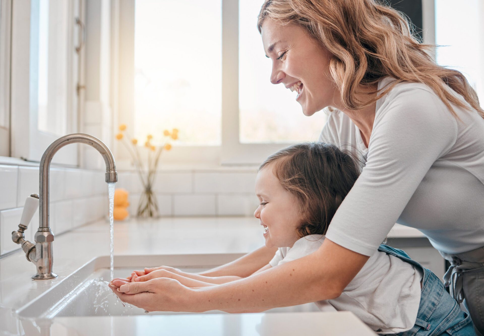 Mother and daughter washing hands in kitchen for hygiene, cleaning and water to protect against germs. Avoid Costly Plumbing Issues with Allen Heating & Cooling