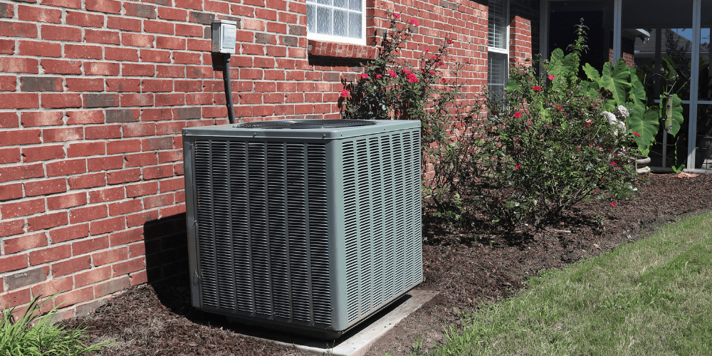 Outdoor AC Condenser Unit Outside of a Residential Home near the Wall integrated into the landscaping - Blog post: 3 Common Air Conditioning Problems to Watch for This Summer - Allen Heating Cooling & Plumbing